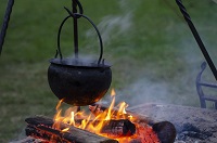Outdoor cooking pot over camp fire.